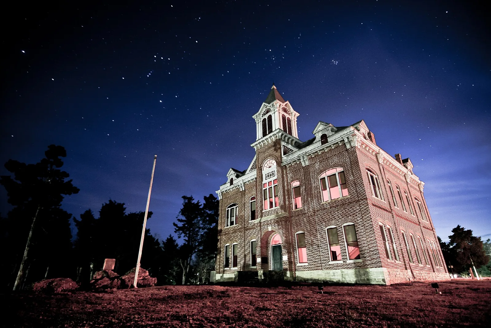 Brick courthouse with a cupola lit against a starry night sky