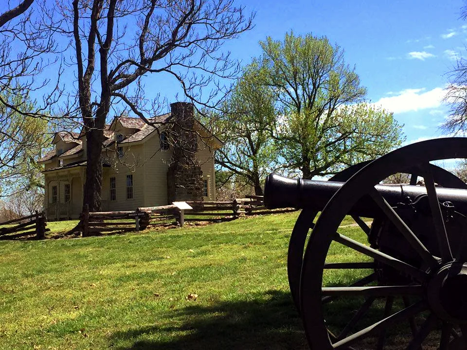 Civil War cannon in the foreground with a historic house behind it