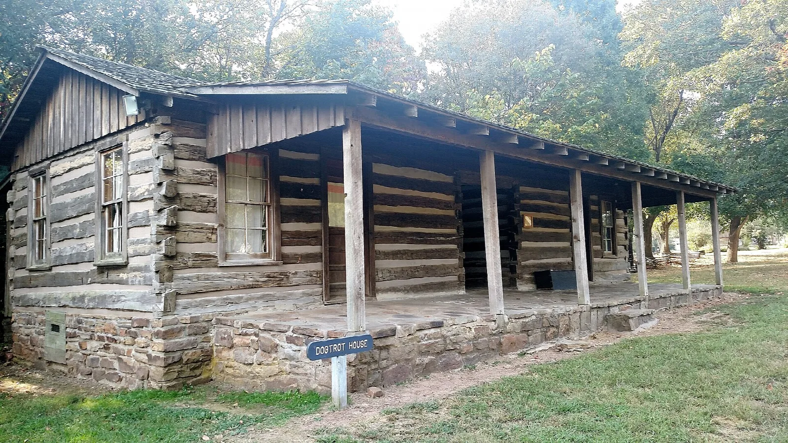 Old log dogtrot house with a long covered porch