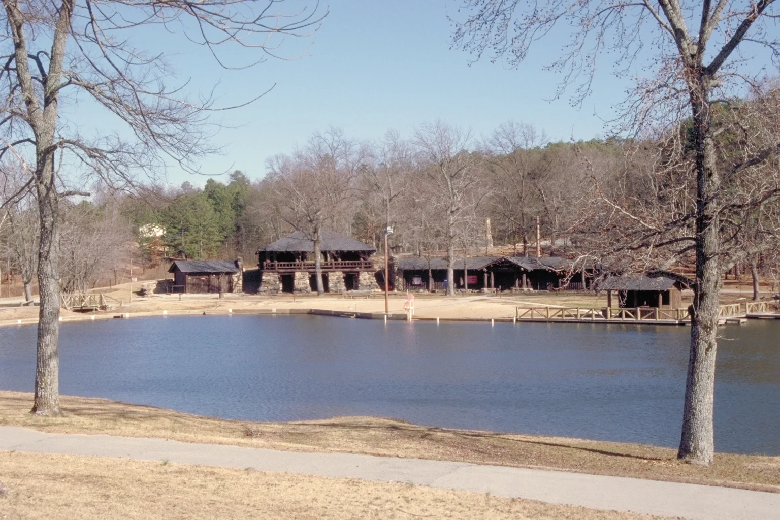 Pond with a log shelter on the far shore among bare trees
