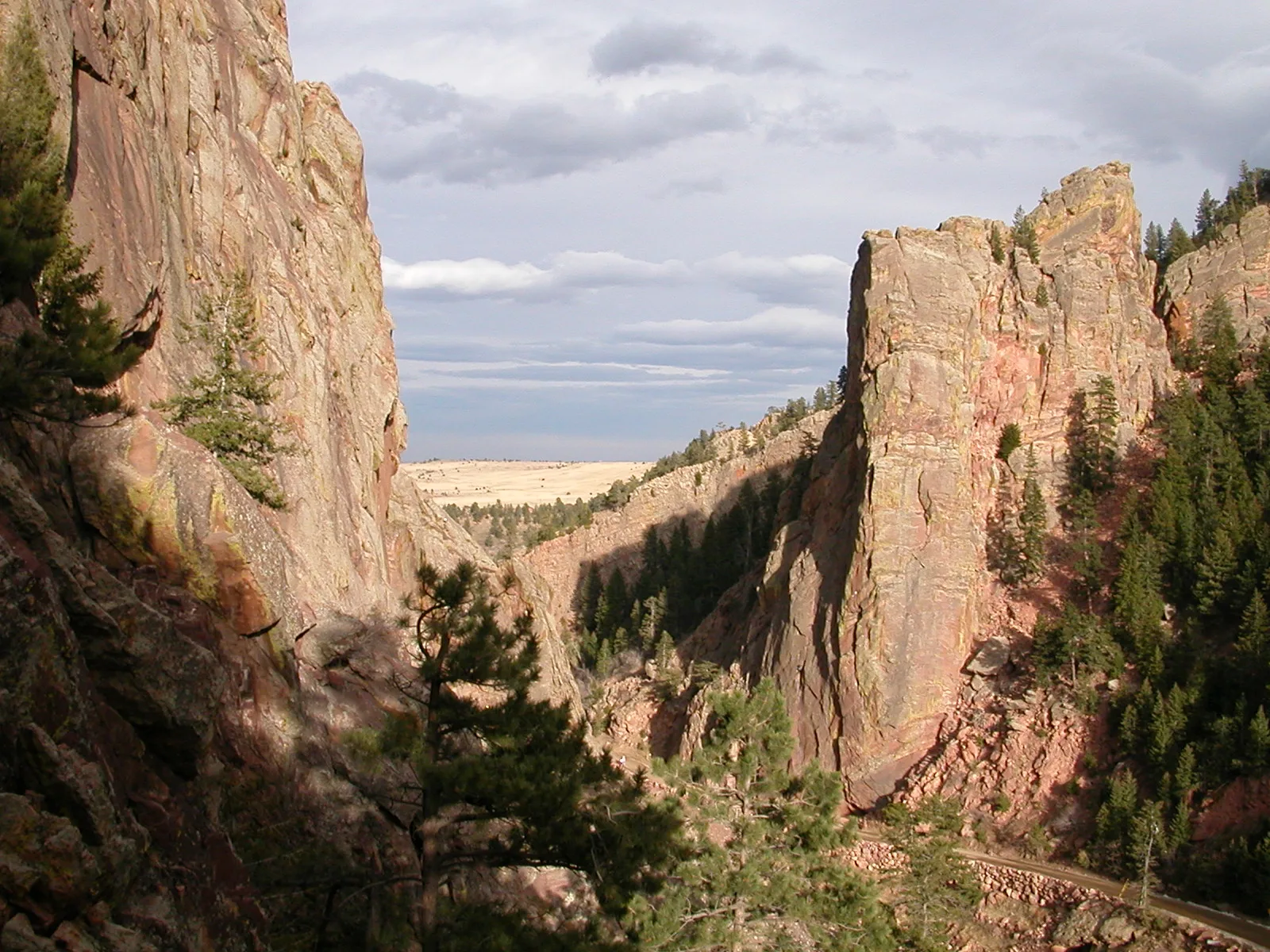 A narrow canyon between tall red rock walls opening to the plains