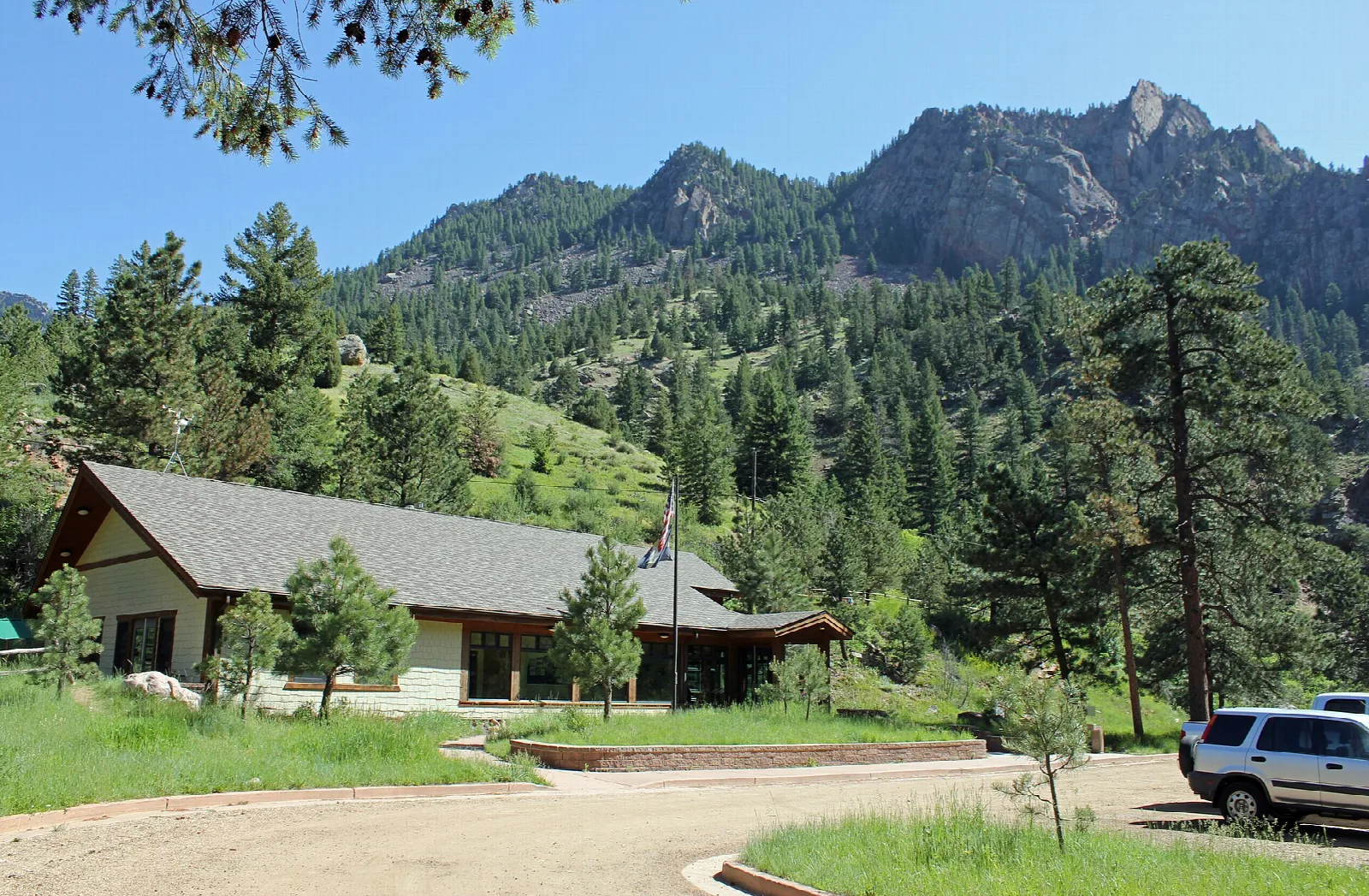 Visitor center building among pines with a forested peak behind