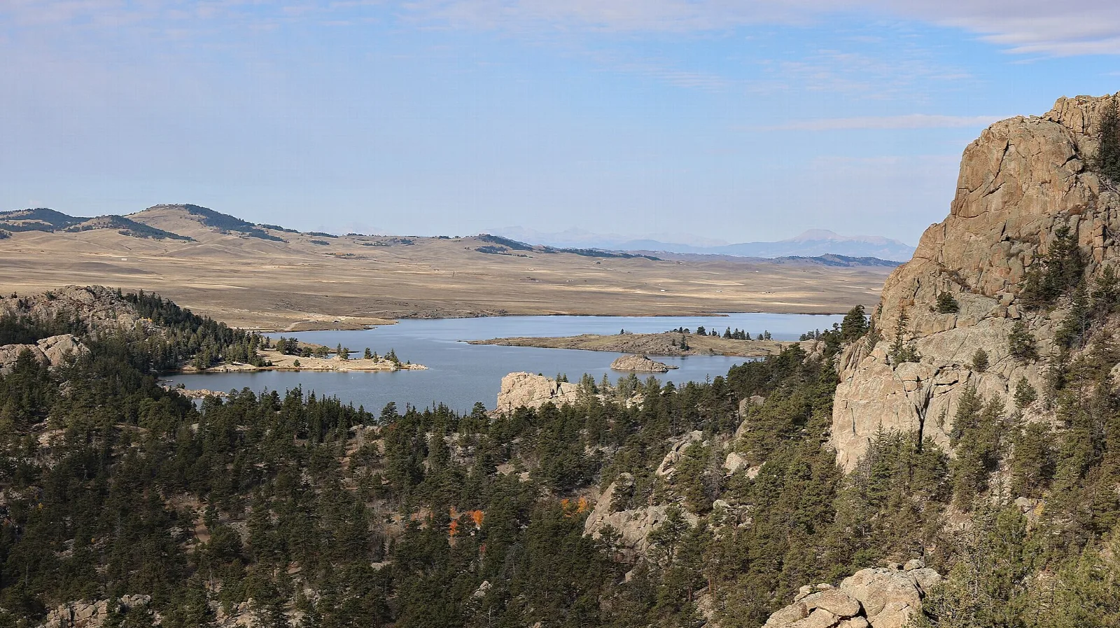 A reservoir below a rock outcrop with open plains beyond