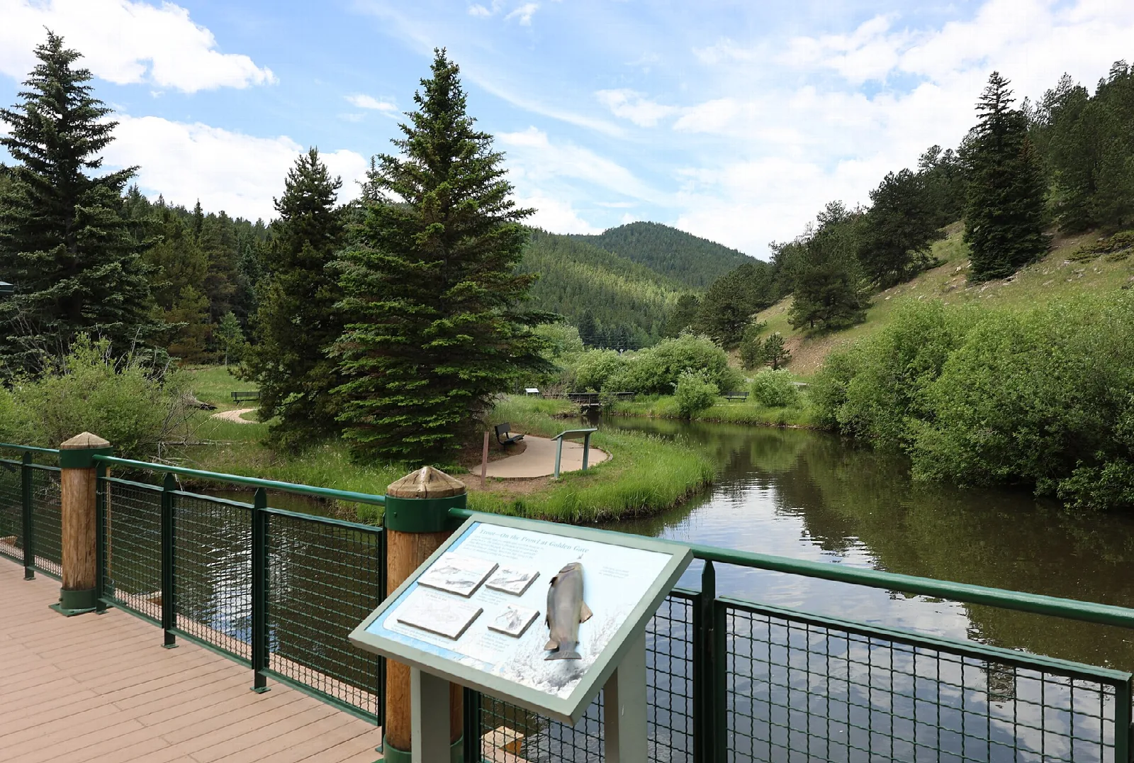 A boardwalk overlook above a pond with an interpretive sign