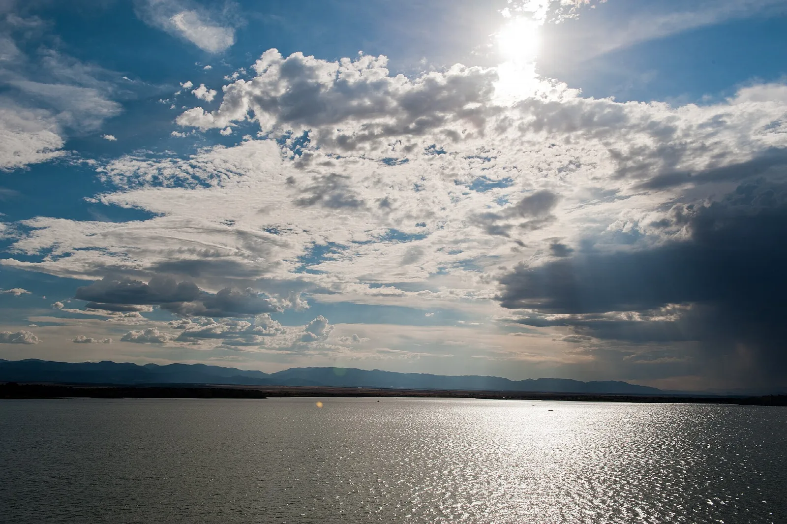 Late afternoon sun reflecting on the lake under dramatic clouds
