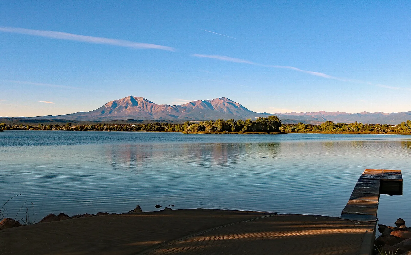 Calm lake and boat ramp with the Spanish Peaks at sunset