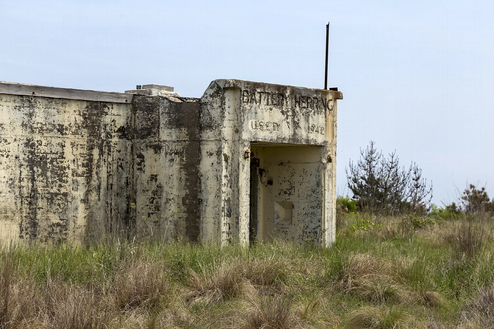 Weathered concrete gun battery building in grass