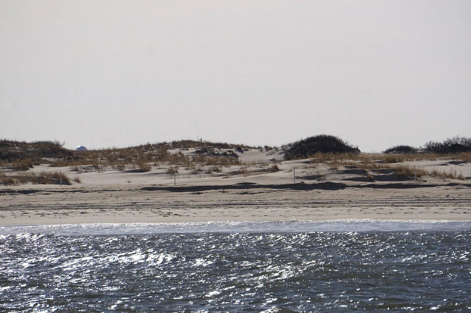 Dunes and marsh across sparkling water