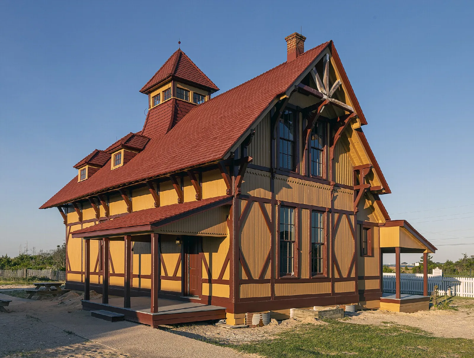 Red-roofed half-timbered lifesaving station building beside sand and water