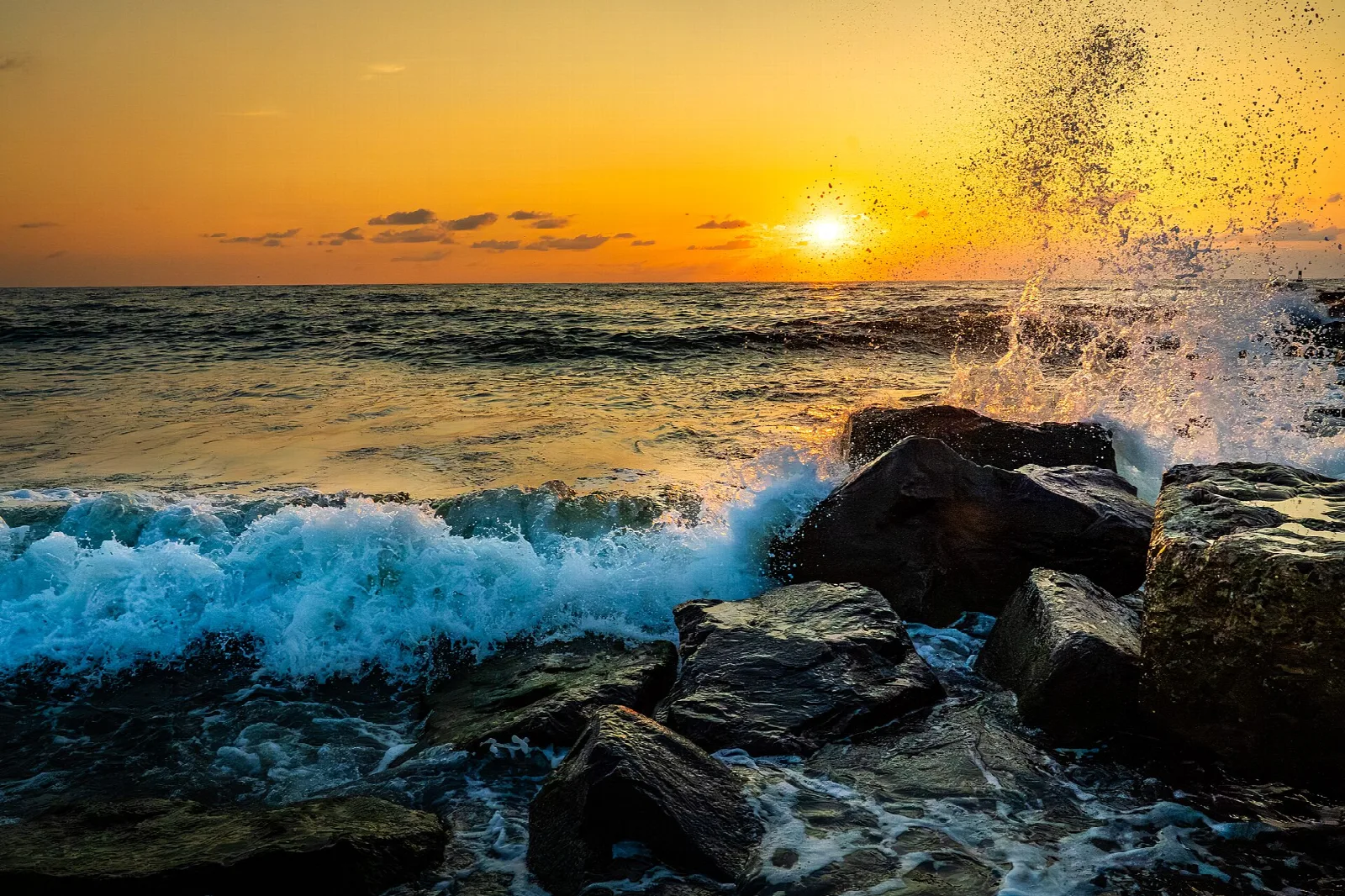 Waves crashing on rocks at sunrise