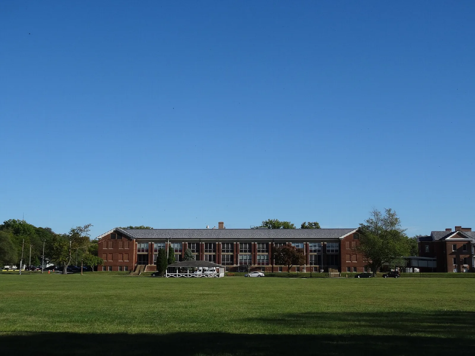 Brick buildings across a large open lawn under blue sky