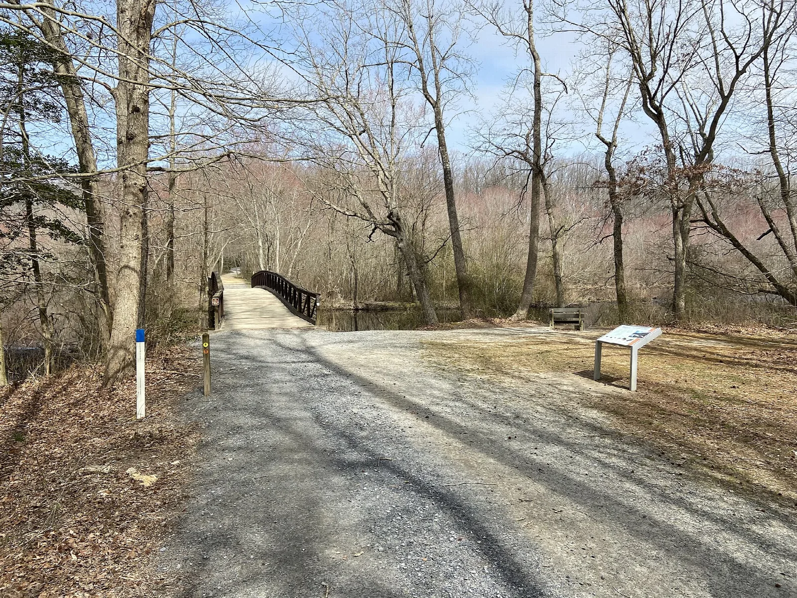 Gravel footpath leading to a footbridge through bare trees