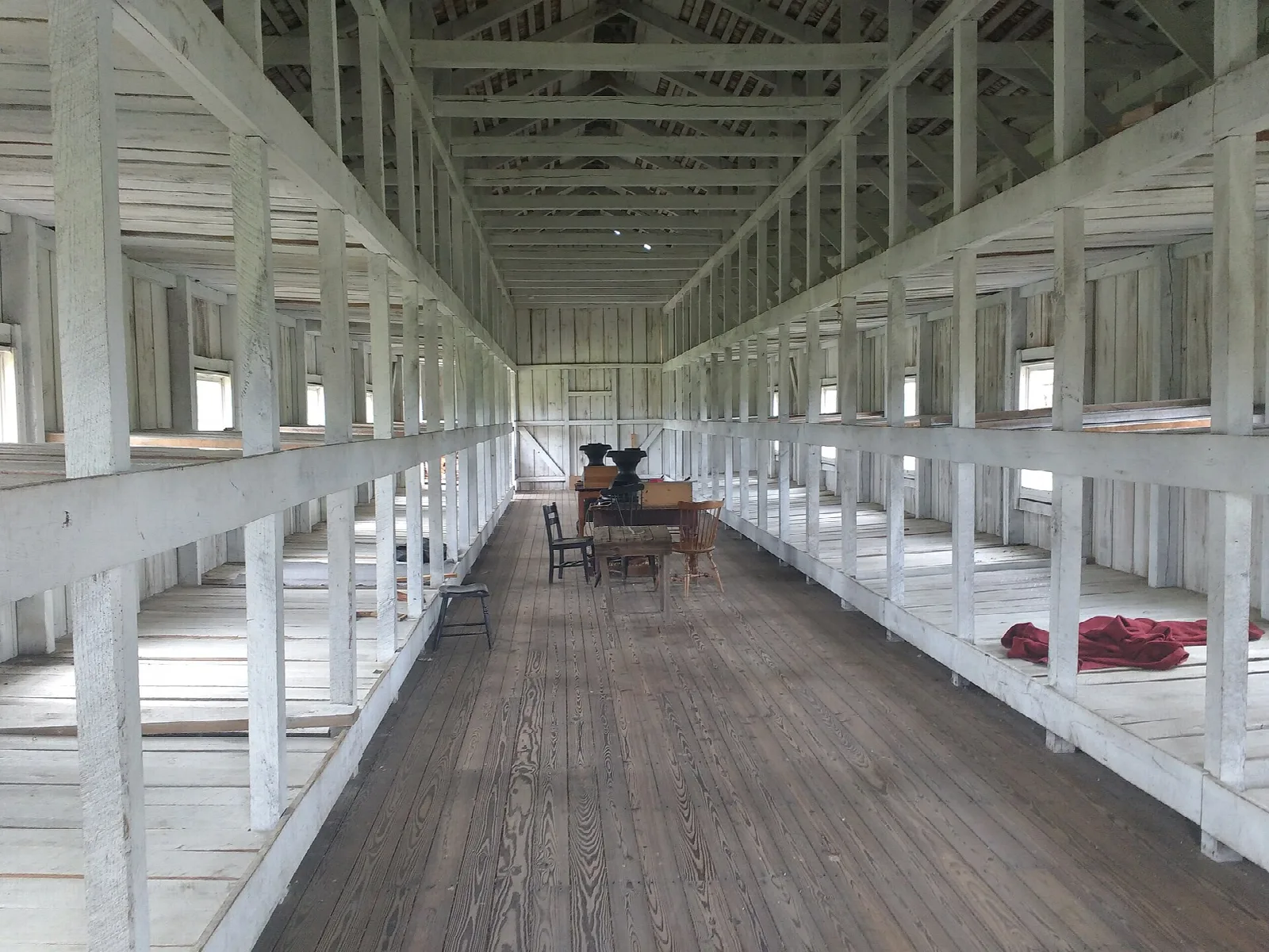Long wooden barracks interior with bunks along both sides