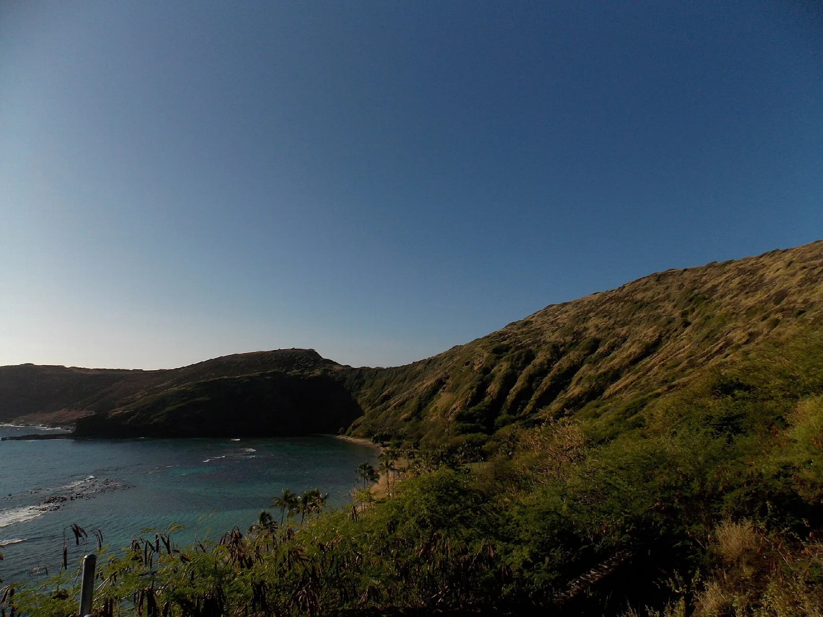 Sheltered bay below a dry green ridge on the southeast side of Oahu