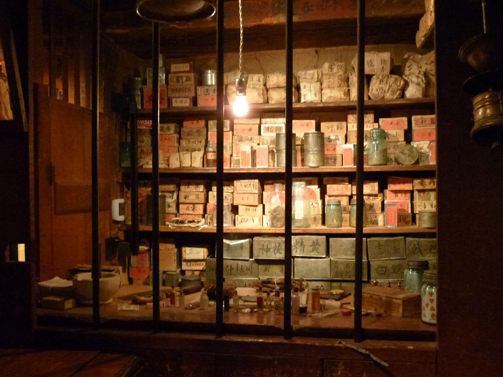 Shelves of boxed goods behind a glass-paned apothecary window