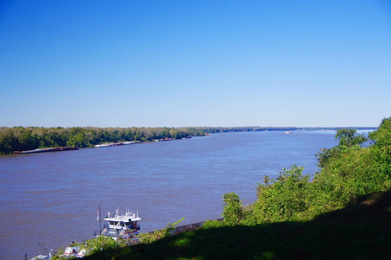 Mississippi River looking north from a tree-covered bluff under a clear blue sky