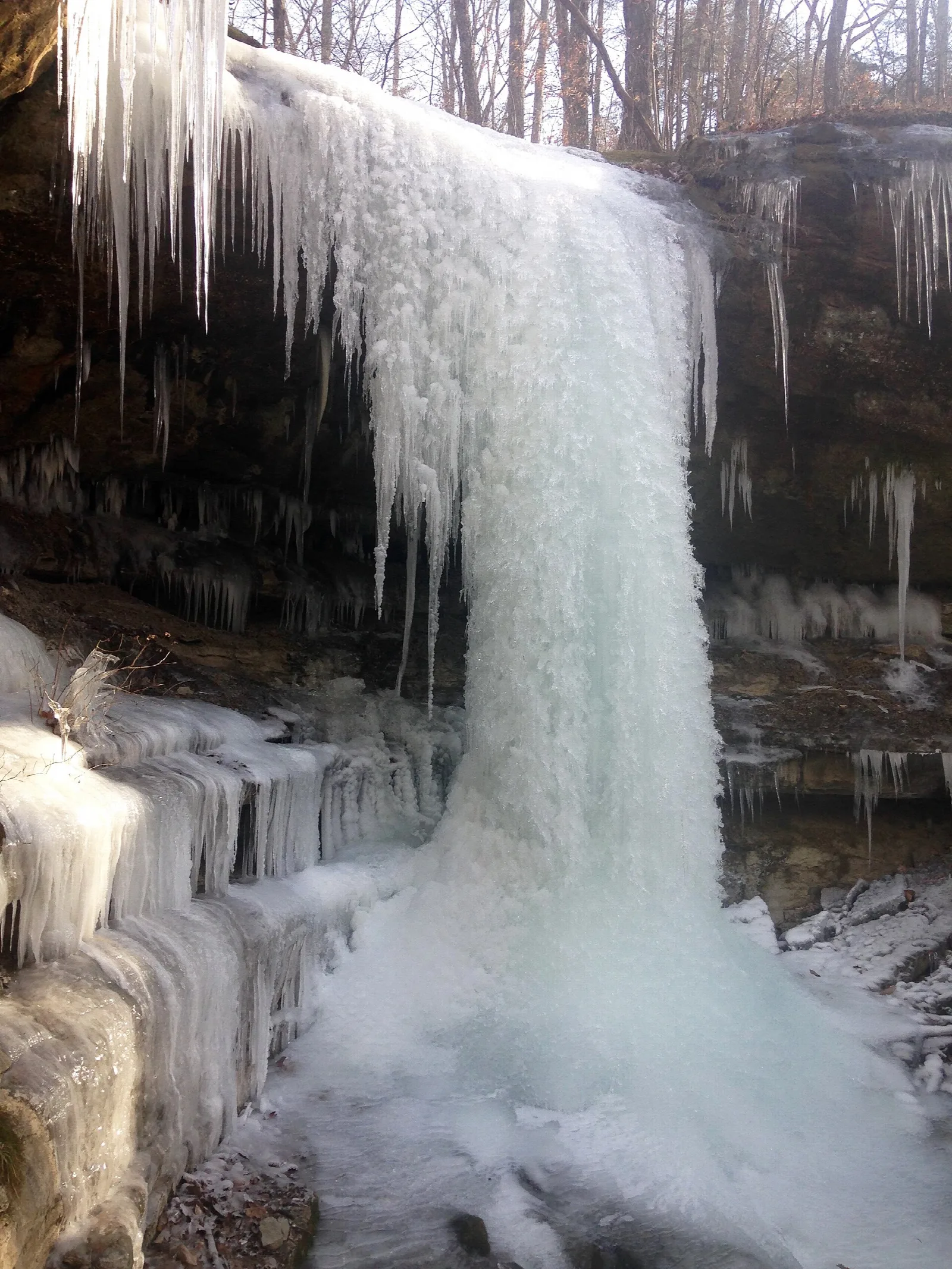 Frozen waterfall of ice and icicles spilling over a rock ledge