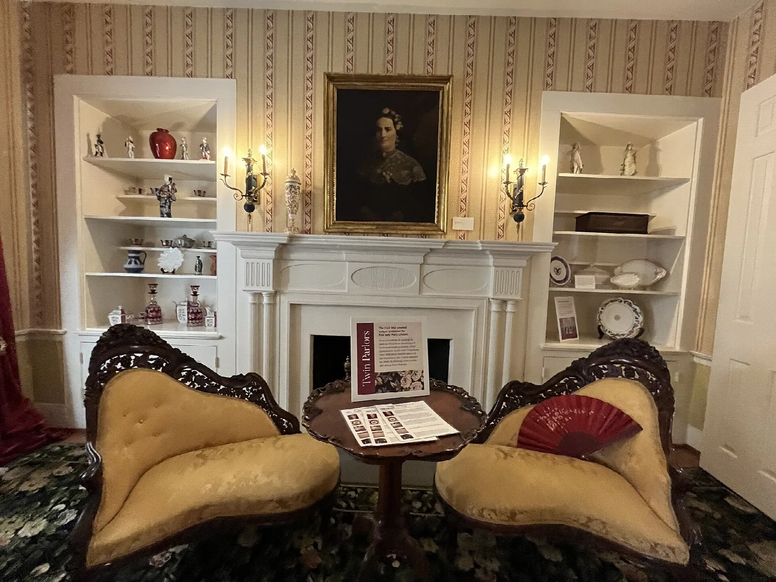 Room with two cream settees, a fireplace and a framed portrait above it