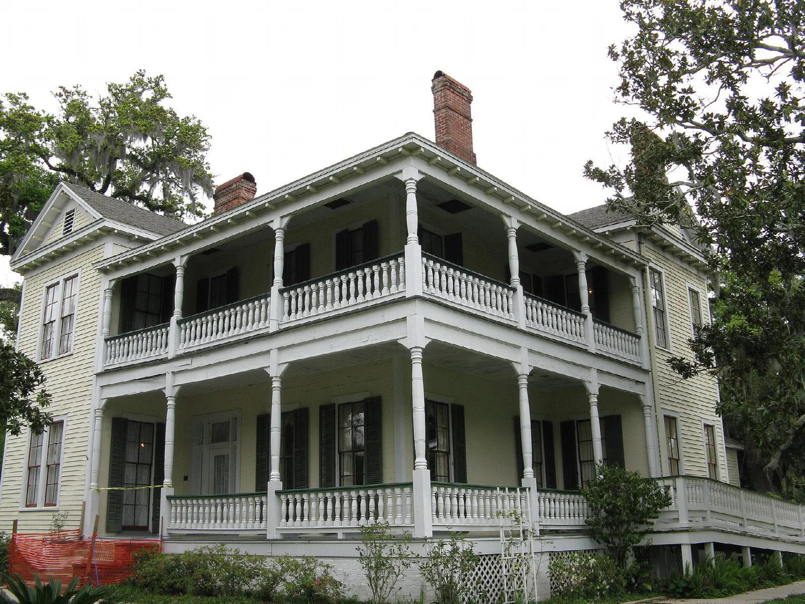 Two-story white house with double-decker porches, seen from a corner