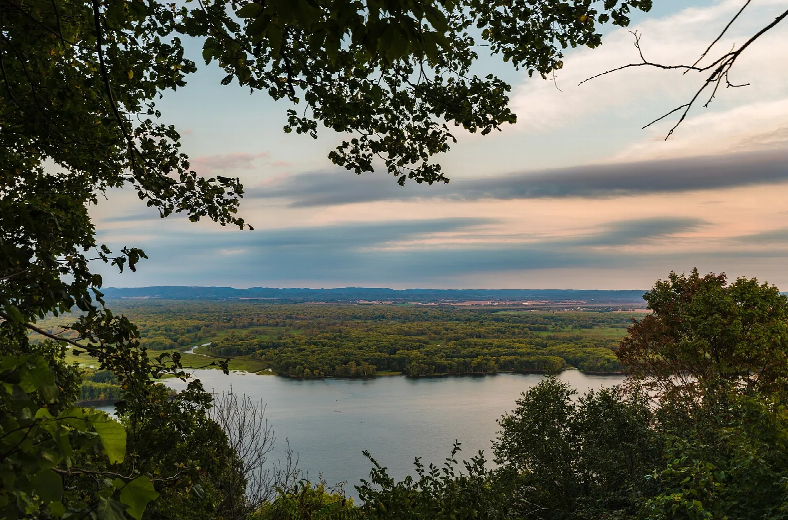 River and islands seen through tree branches at sunset