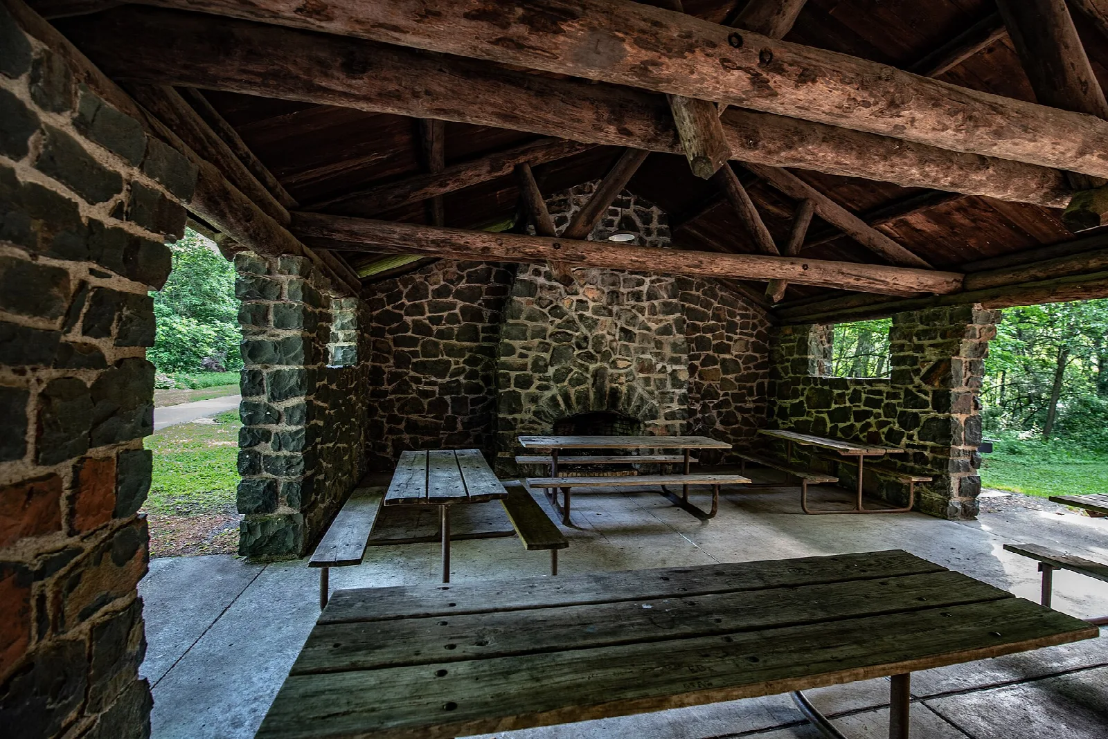 Stone picnic shelter with a fireplace and picnic tables