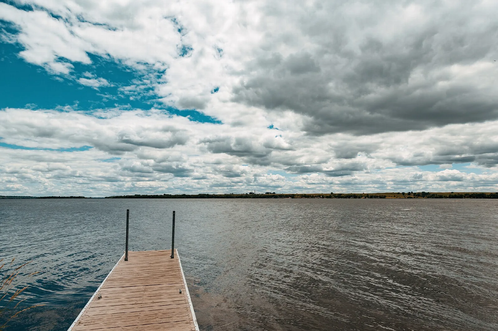 Wooden dock over choppy gray water under a cloudy sky