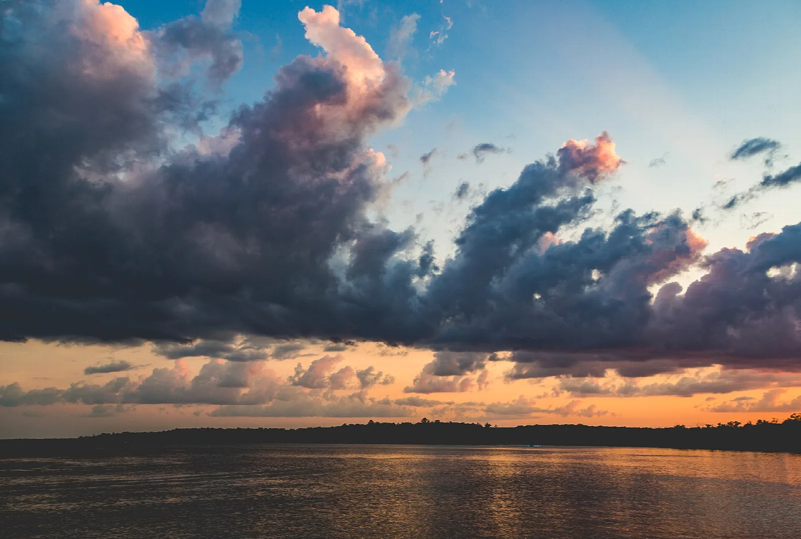 Sunset clouds in orange and purple over a calm lake