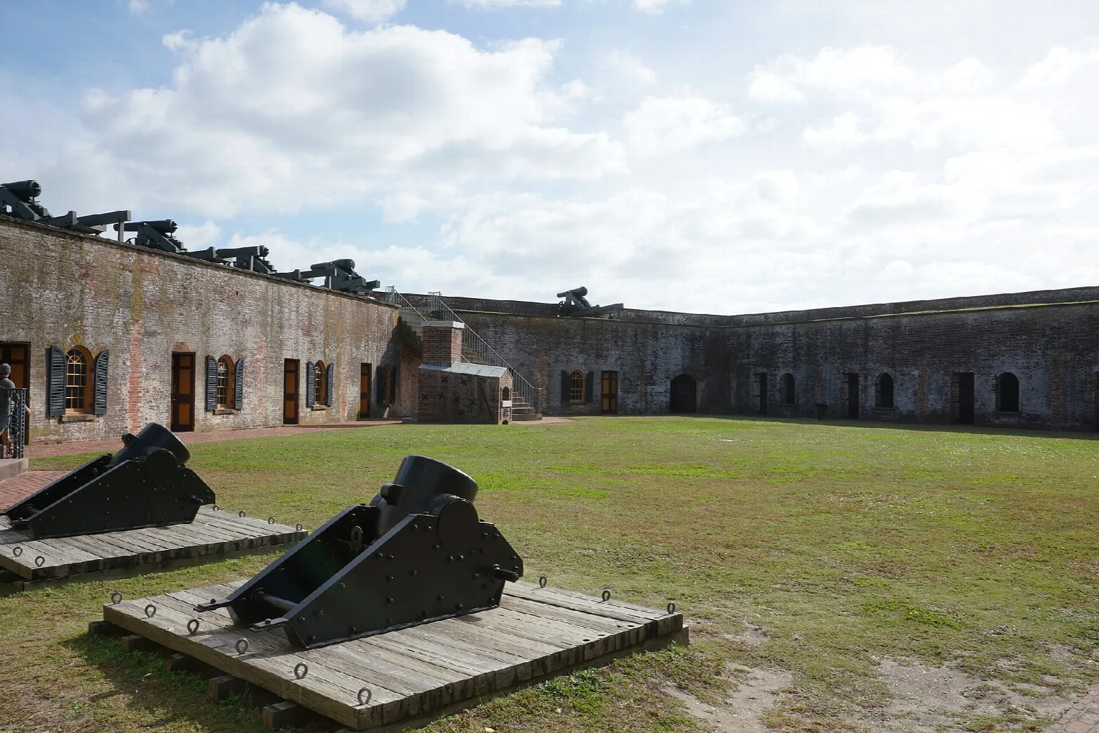 Black cannons on wooden platforms inside the fort walls