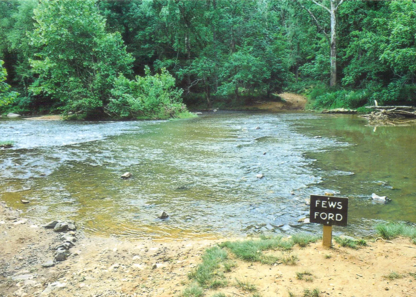 Wide shallow river crossing with a small Fews Ford sign on the bank