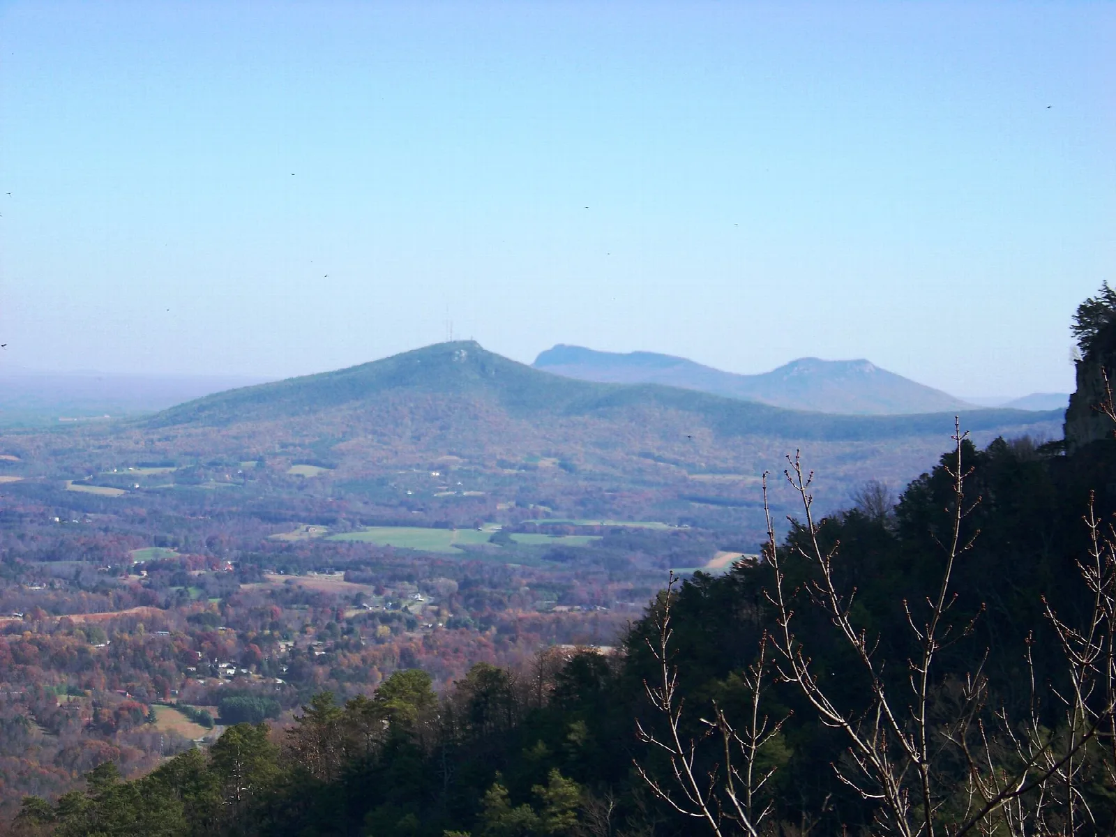 Distant forested mountain seen across a valley from a ridge