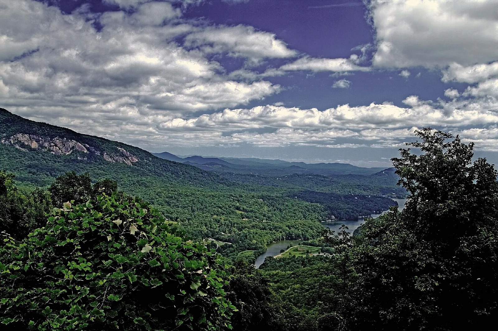 Forested mountains and a gorge under a dramatic cloudy sky