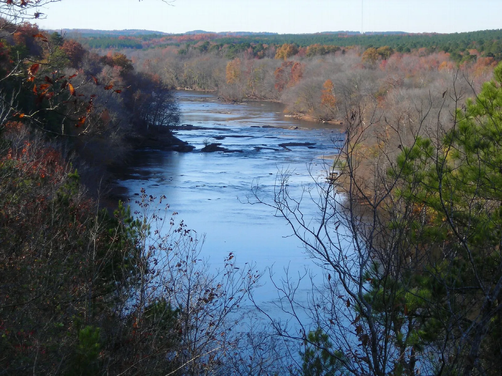 Blue river winding between forested bluffs with autumn color