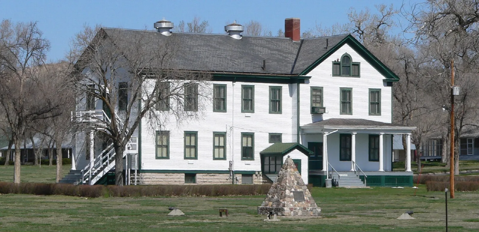 White two-story headquarters building with a small tepee-shaped marker on a lawn