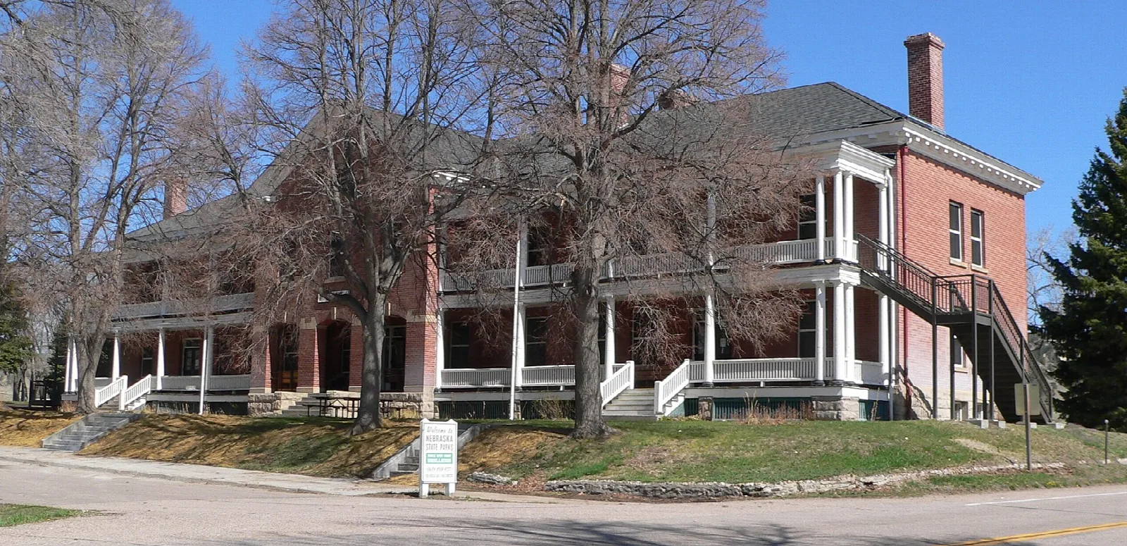 Large red brick building with a wide porch and outside staircase