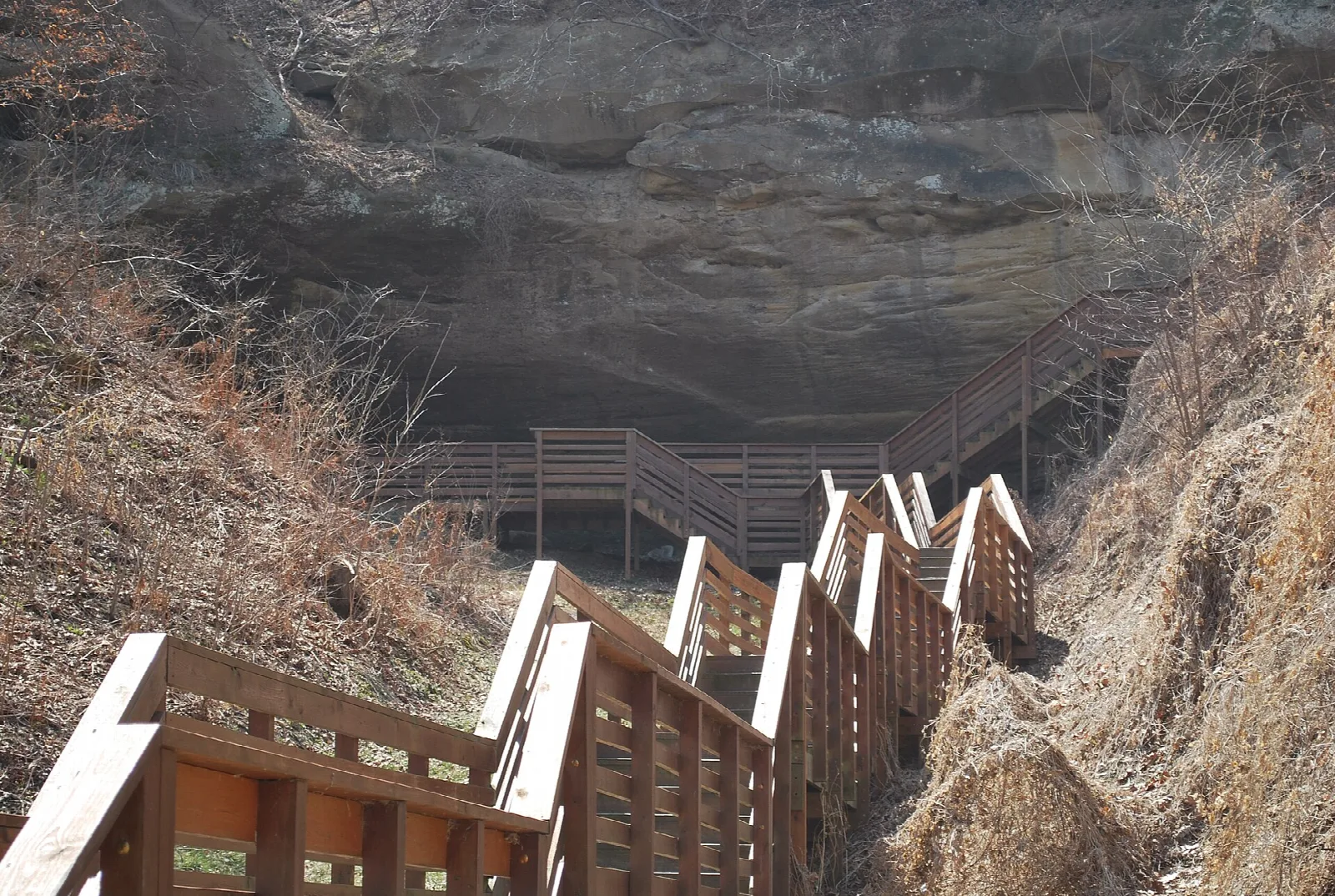 Wooden stairs leading up to a large rock shelter