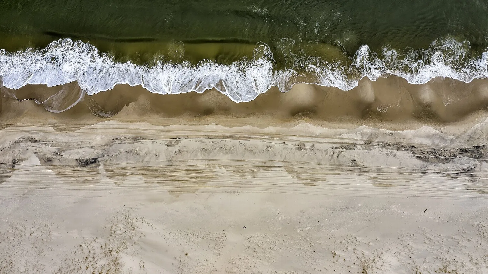 Overhead view of waves washing onto a sandy beach