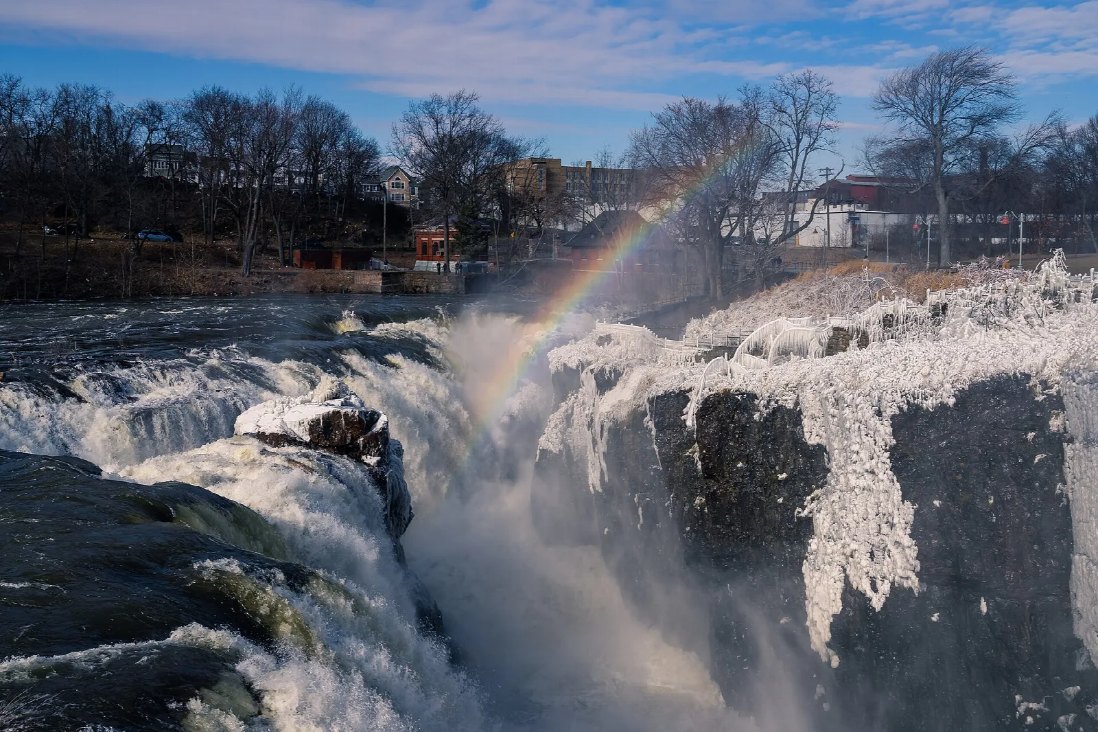 Rainbow over churning water at the top of the falls