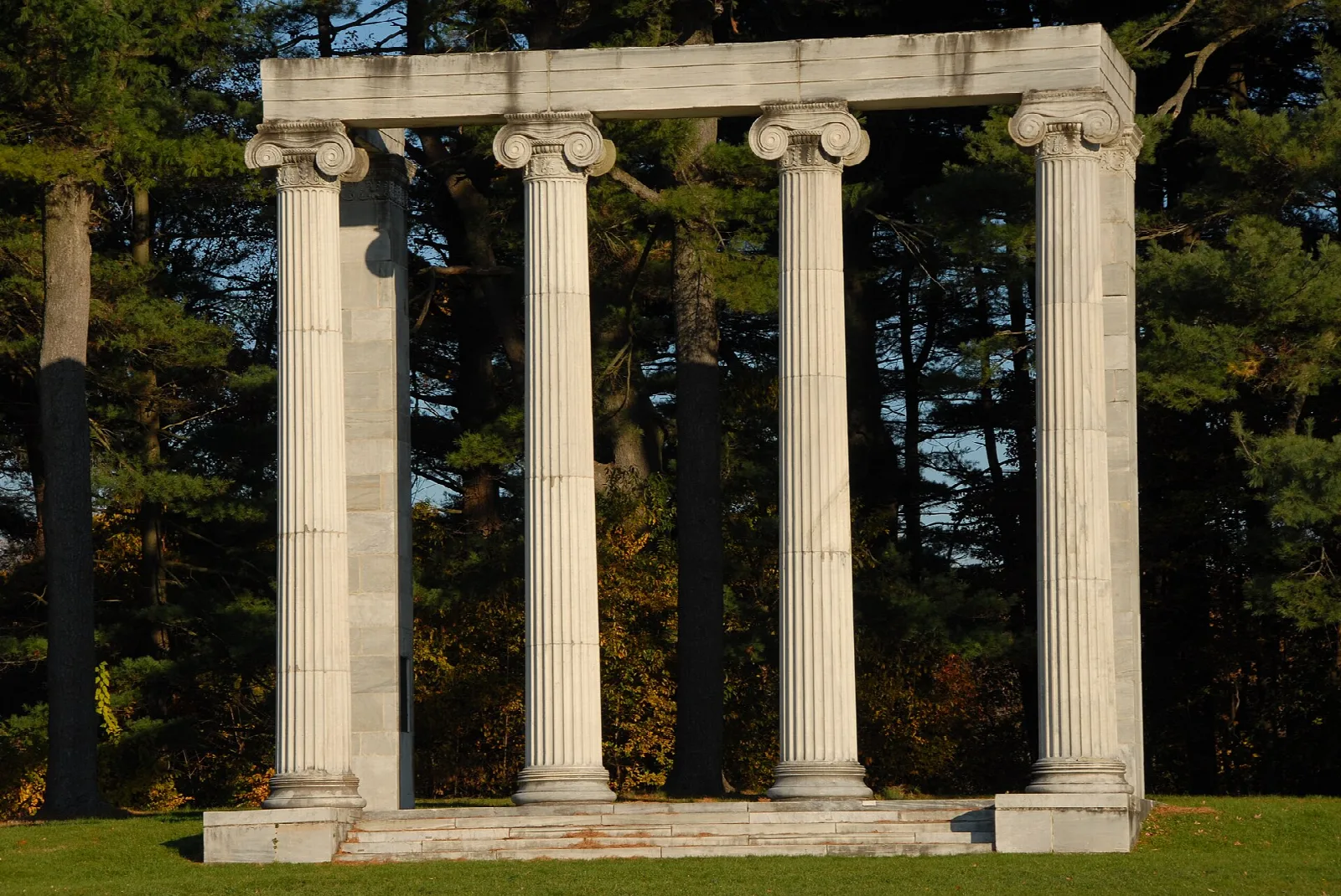 Stone columns framed by dark evergreen trees