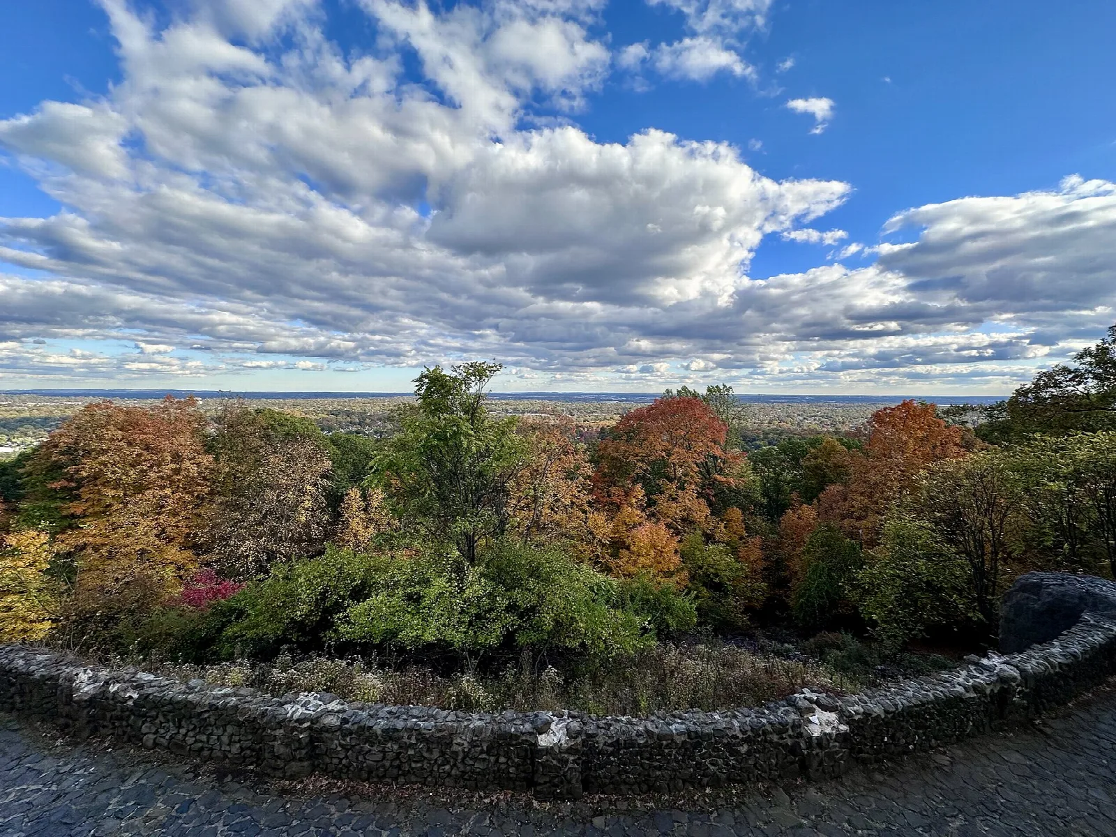 Stone overlook wall with autumn trees and wide view to the horizon
