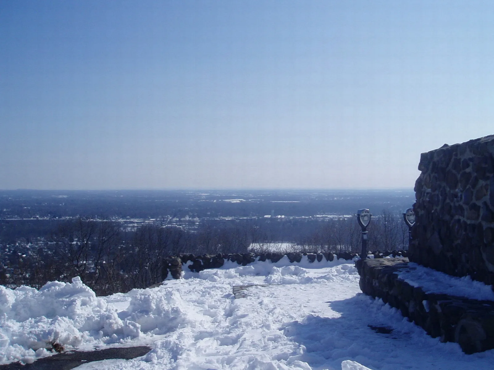 Snowy stone overlook with a hazy view over the lowlands