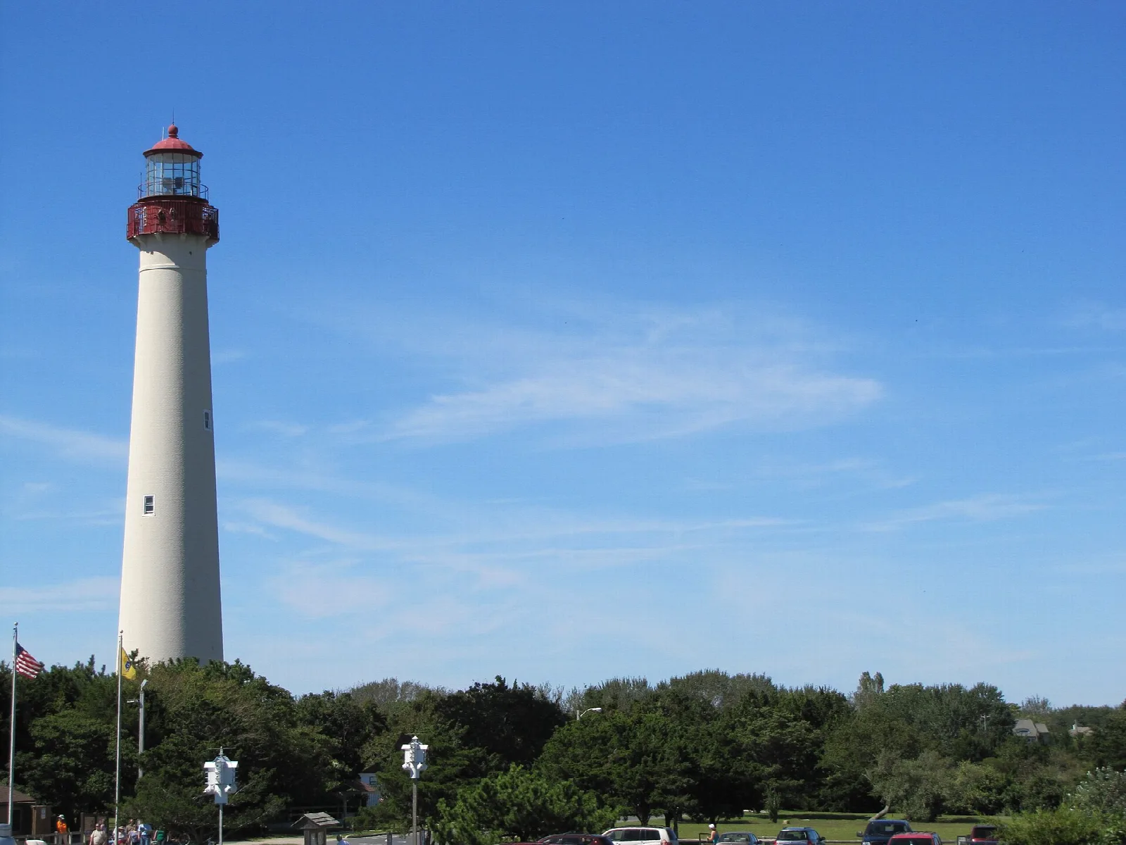 Tall white lighthouse with a red top against a blue sky