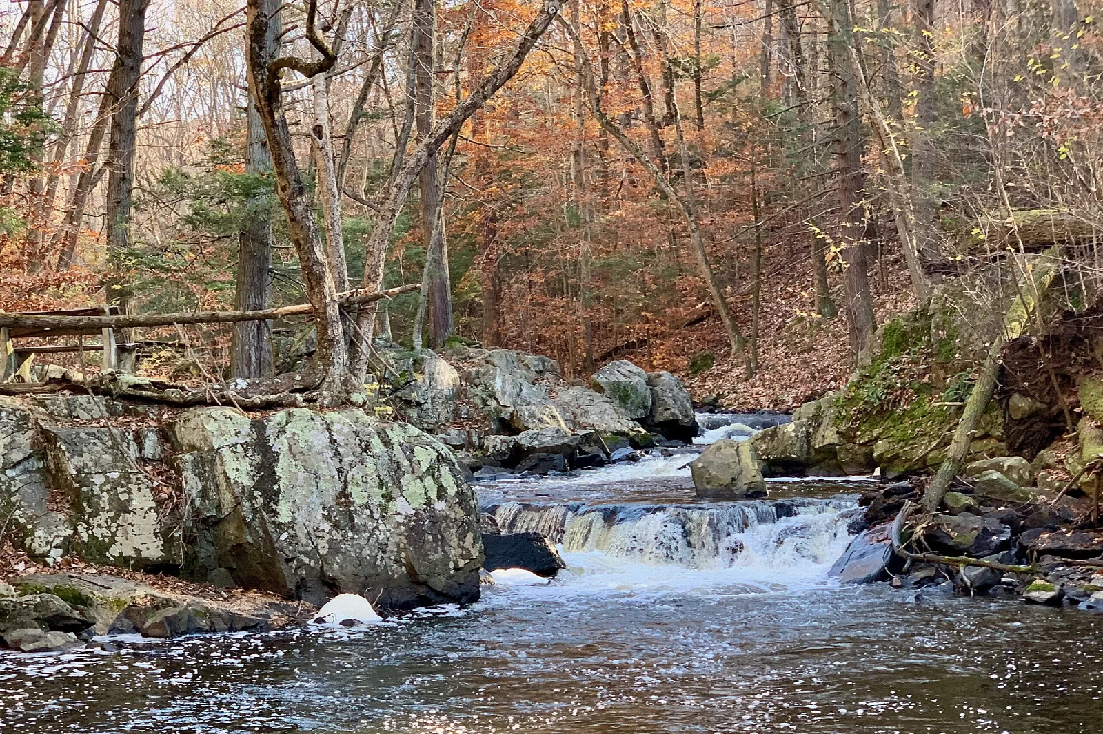 Small waterfall over rocks in a stream in fall woods
