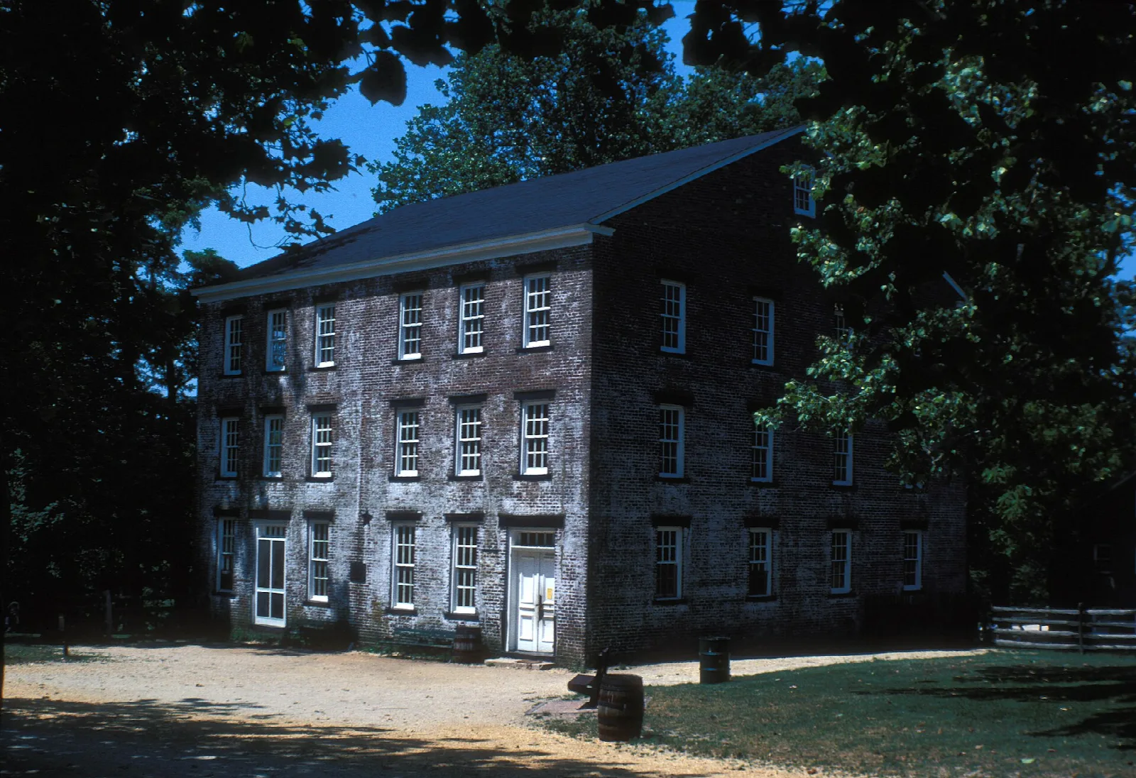 Old multi-story brick building among trees