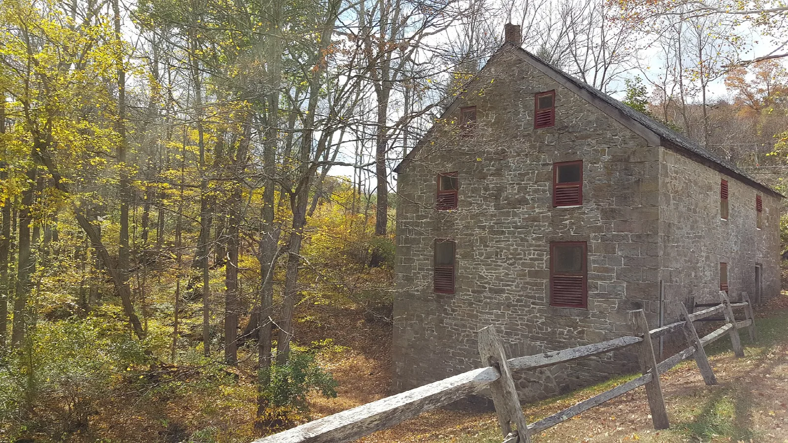 Old stone mill building among autumn trees