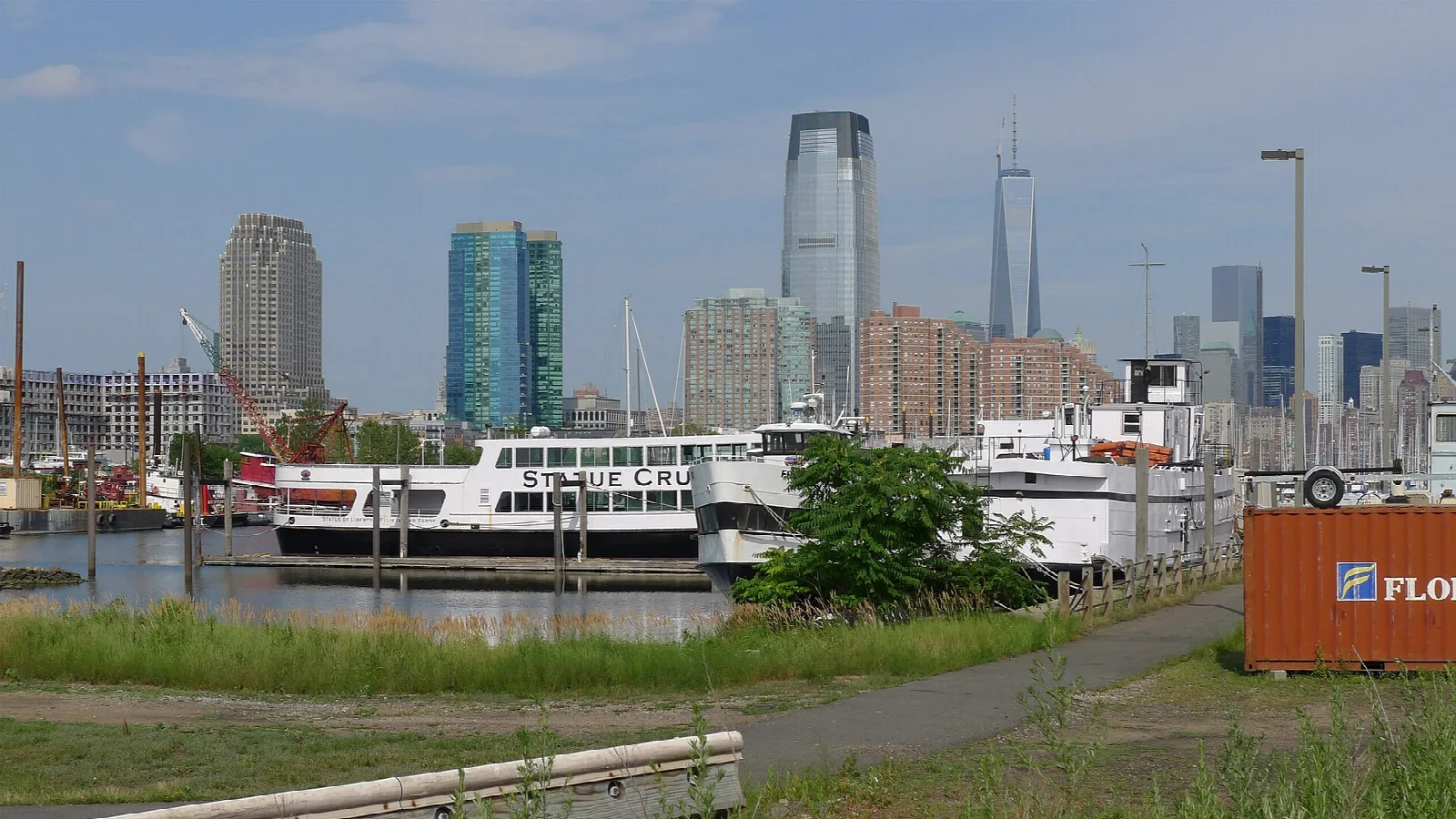 Ferries at a pier with a city skyline beyond
