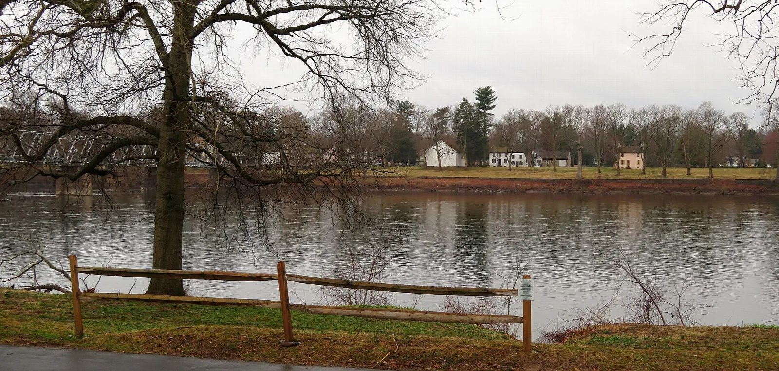 River bank with wooden rail fence and a far shore