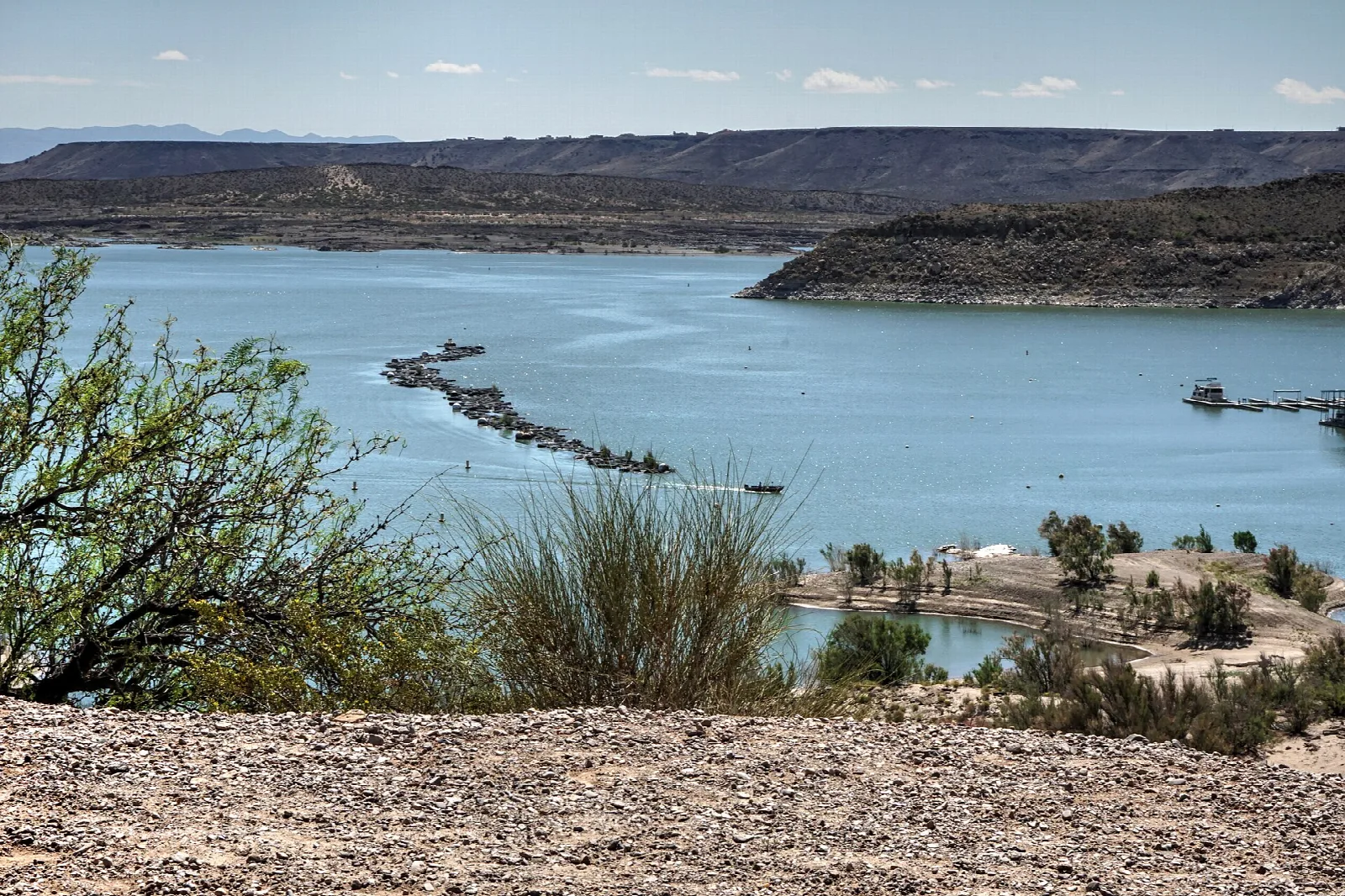 Reservoir winding between rocky desert shores under a pale sky