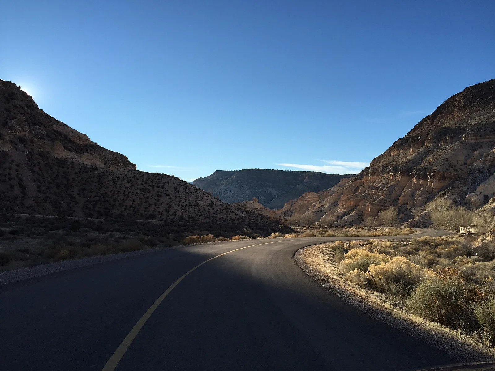 Park road winding between dark canyon walls in shade