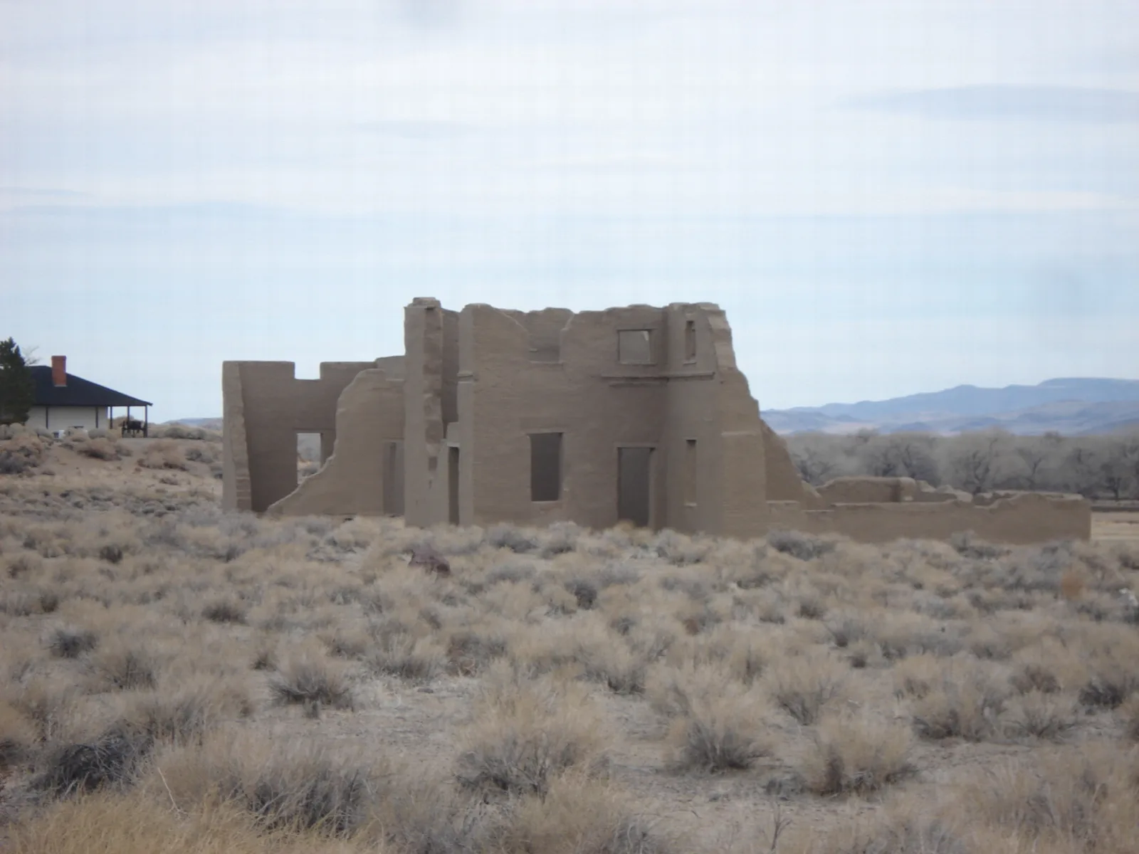 Crumbling adobe walls in a sagebrush flat