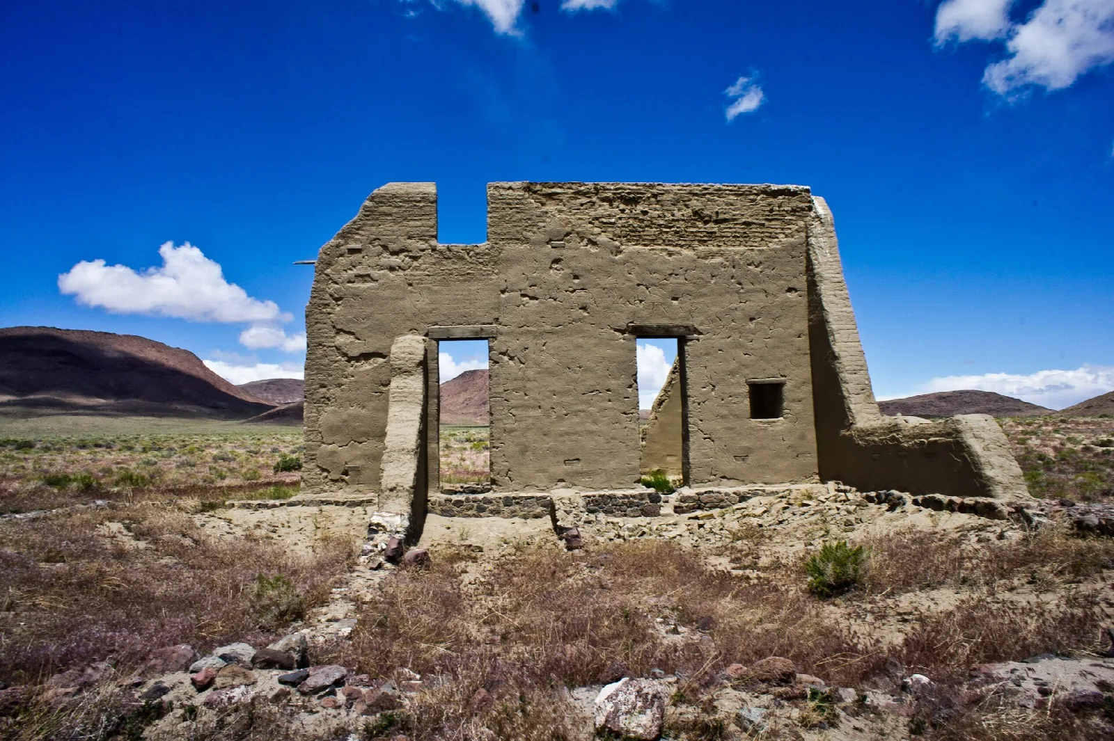 Adobe fort ruin with window openings under a bright blue sky